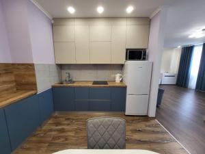 a kitchen with a refrigerator and a chair in a room at ObolonSky apartament on Obolon in Kyiv