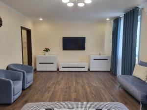 a living room with a couch and a tv at ObolonSky apartament on Obolon in Kyiv +3 photos