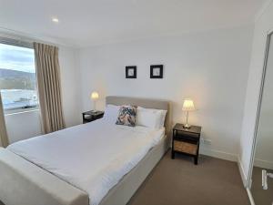 a bedroom with a large bed and two lamps on tables at City Centre Apartment 17 in Turner
