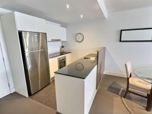 a kitchen with a stainless steel refrigerator and a table at City Centre Apartment 17 in Turner