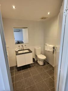a bathroom with a toilet and a sink and a mirror at City Centre Apartment 17 in Turner