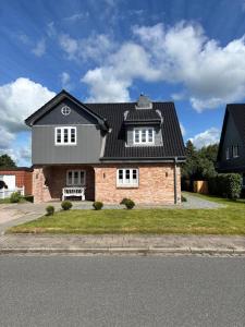 ein großes Backsteinhaus mit schwarzem Dach in der Unterkunft Ferienhaus Swinemünde mit Sauna und Whirlpool exkl buchbar in Tönning