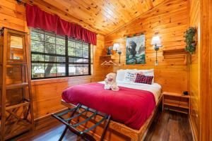 a teddy bear sitting on a bed in a wooden room at In Green Pastures Gatlinburg in Sevierville