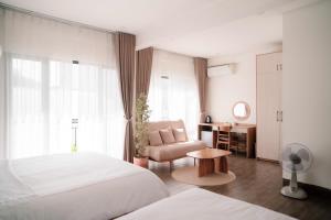 a bedroom with a bed and a chair and a desk at Glory 2 Hue Homestay in Hue +168 photos