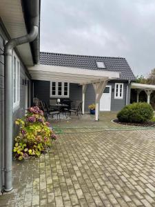 ein Haus mit einer Terrasse mit einem Blumenstrauß in der Unterkunft Ferienhaus Swinemünde mit Sauna und Whirlpool exkl buchbar in Tönning