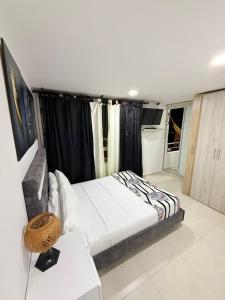a bedroom with a bed with black curtains at Arboleda Real Hospedaje in Armenia