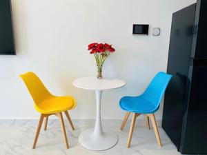 une table avec deux chaises et un vase de fleurs dans l'établissement SEN Vinhome Grand Park Q9, à Long Bình