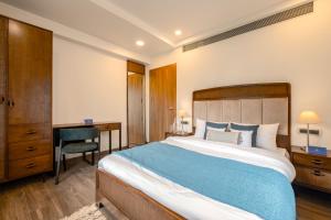 VeremSaffronStays Vento - 4BR villa with pool, elevator, chic interiors & sunlit spaces, near Candolim, Calangute & Baga的一间卧室配有一张大床、一张桌子和一把椅子 更多5张照片