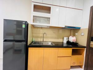 une petite cuisine avec un évier et un réfrigérateur dans l'établissement SEN Vinhome Grand Park Q9, à Long Bình