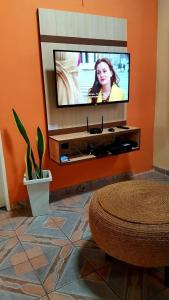 a living room with a flat screen tv on a wall at Casa Santos in Santo Amaro