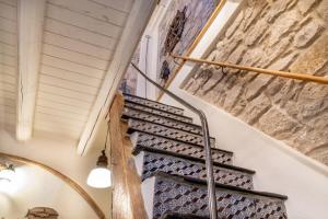 a spiral staircase in a house with a stone wall at Casa Ancora in Carloforte
