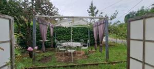 a gazebo with a table and chairs in a yard at Havre de paix à la campagne in Ronchamp +5 photos
