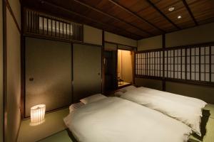 a bedroom with two beds and a lamp in it at Natsume an Machiya House in Kyoto