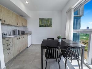 a kitchen with a black table and chairs in it at Shoreline Urban Suite in Herzliya B +15 photos