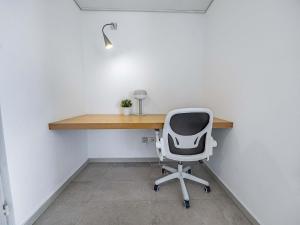 an office with a desk and a white chair at Shoreline Urban Suite in Herzliya B
