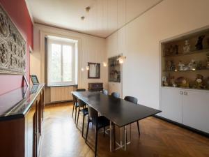 a dining room with a black table and chairs at LuxRent Penthouse Crimea in Turin