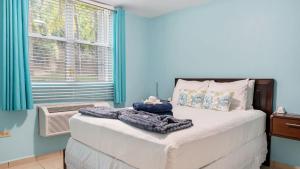 a bedroom with a bed with a blanket and a window at Landing View 203 with private rooftop terrace in Rincon +19 photos