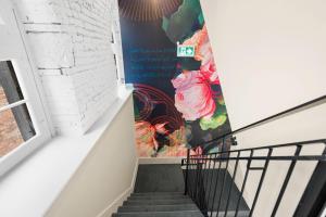a stairway with a mural of flowers on the wall at Arcadia Hotel Boutique in Montreal