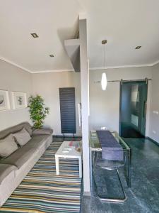 カンネロ・リヴィエーラにあるAppartamento Eleganteのソファとガラスのテーブルのあるリビングルーム