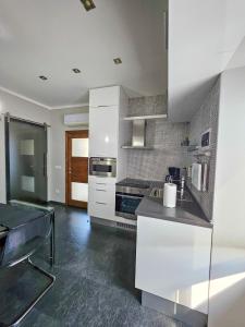 カンネロ・リヴィエーラにあるAppartamento Eleganteの白いキャビネットとカウンタートップを備えたキッチン