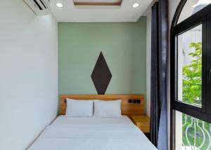 Un dormitorio pequeño con una cama y una ventana. en Lalisa Hotel Grand World Phu Quoc, en Phu Quoc