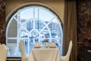 a table in a restaurant with a large window at Emaar Al Mektan Hotel in Medina