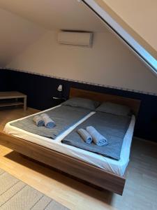 a bed with two pairs of towels on it at Heera Apartman in Hajdúszoboszló