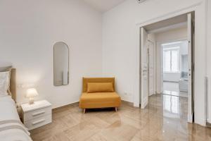 a bedroom with a bed and a chair in it at FaMa - Mecenate 3BR & 2BA in Rome