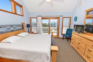 a bedroom with a bed and a flat screen tv at Semi-Oceanfront, Priv Pool, Hot Tub, ELEV, Rec Rm-WL980, OBX Beach Bliss in Corolla +47 photos