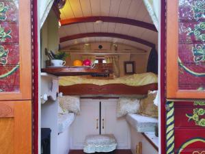 a small room with a bed in a tiny house at The Gypsy Knot in Wells next the Sea +16 photos