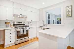 a kitchen with white cabinets and a stove top oven at Historic 3 BR Home - 15 Min Walk to N-MC Stadium in Annapolis