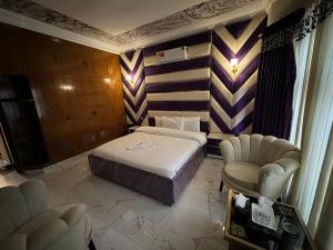 a hotel room with a bed and two chairs at Millat Guest House G94 in Islamabad +9 photos