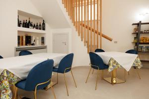 a dining room with a white table and blue chairs at La Dimora del Duca in Palma di Montechiaro