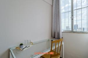 een stoel in een kamer met een raam bij Suite no Centro do Rio com vista para a cidade in Rio de Janeiro +10 foto's