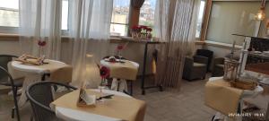 a restaurant with two tables and chairs and a window at HOME DOLCE LUNA in Castelvetrano Selinunte