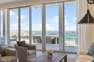 una sala de estar con puertas correderas de cristal y vistas al océano. en Luxurious Penthouse Condo with Stunning Gulf Views! #402 Viridian in Seagrove 5BR Sleeps 12 condo, en Santa Rosa Beach