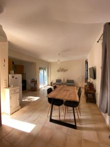 a kitchen and living room with a wooden table and chairs at Maison à côté lac proche mer FANOU HOUSE in Georgioupoli