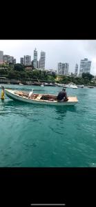 a man is sitting in a boat in the water at Kitnet compacta in Salvador
