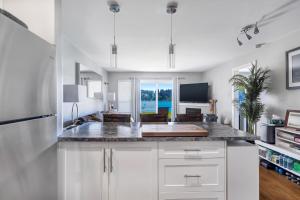 Shawnigan LakeにあるLakefront Suite on Shawnigan Lakeの白いキャビネットとカウンタートップを備えたキッチン