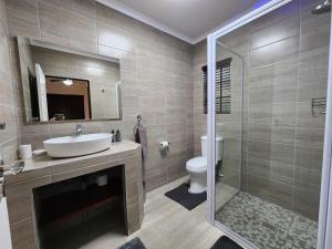 a bathroom with a sink and a toilet and a shower at Kensington Lodge Golf Estate Villa - 17 Pinehurst Drive in White River +43 photos