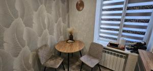 un tavolo e delle sedie in una stanza con una finestra di Затишні апартаменти зі сховищем на Святогеоргієвській 15 a Kryvyj Rih