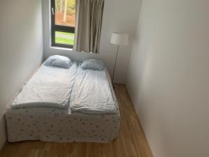 Un dormitorio con una cama en una habitación con ventana. en Private bedroom, en Moss