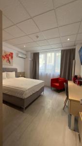 a bedroom with a large bed and a red chair at Heights Accommodation Old Center in Bucharest