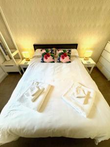 a white bed with two towels on top of it at Bellaview Apartment Barmouth in Barmouth