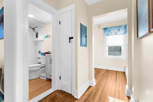 a white bathroom with a toilet and a sink at The Seafarers Stay A Nautically Themed 3BR Flat in Stonington Borough in Stonington +34 photos