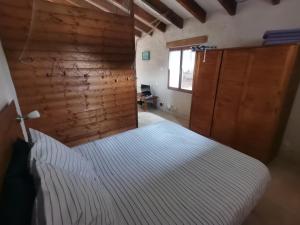 a bedroom with a bed and a wooden wall at Gîtes Le Chemin du Romarin in Meursac +79 photos