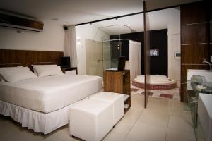 a bedroom with a large bed and a bathroom at Lemon Motel- Piedade in Recife