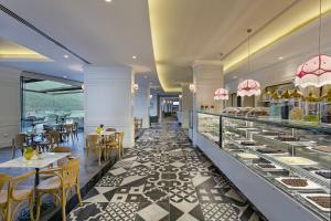 a restaurant with a buffet line with tables and chairs at Titanic Luxury Collection Bodrum in Guvercinlik