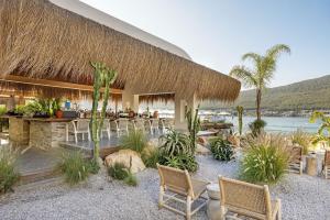 a resort with a bar with chairs and plants at Titanic Luxury Collection Bodrum in Guvercinlik