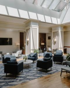 a living room with couches and chairs and a tv at Club Quarters Hotel Rittenhouse Square, Philadelphia in Philadelphia